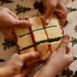 Plusieurs mains cassent un grand biscuit jeu de morpion pour le partager.