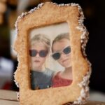 Gros plan sur un biscuit cadre avec photo de deux enfants portant des lunettes de soleil.