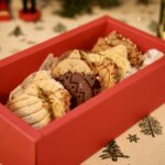 Coffret rouge ouvert de biscuits boules de Noël, vu en diagonale.