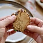 Biscuit de Pâques en forme de lapin tenu en main prêt à être dégusté