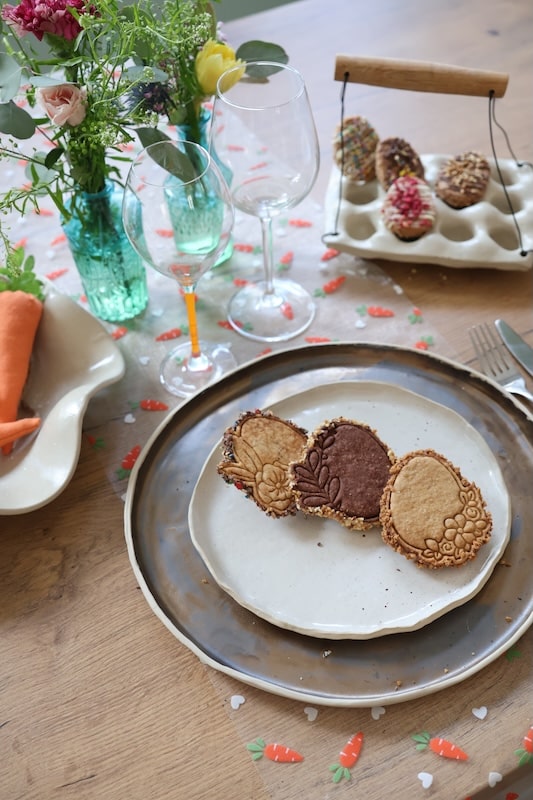Biscuits de Pâques en forme d'œufs présentés sur une table décorée ambiance printemps